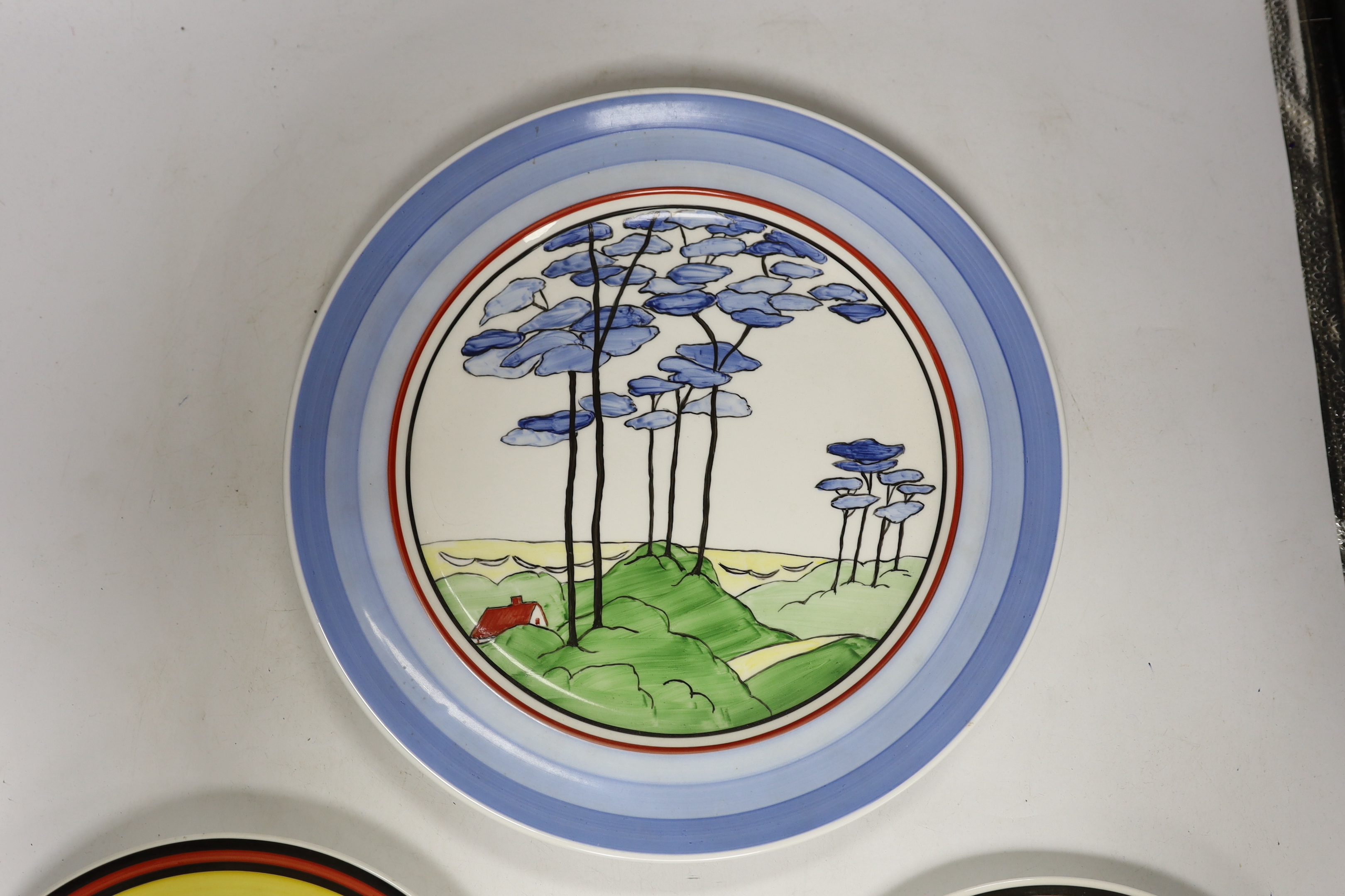 Four Clarice Cliff style plates, a similar vase and a jar and cover, tallest 31cm